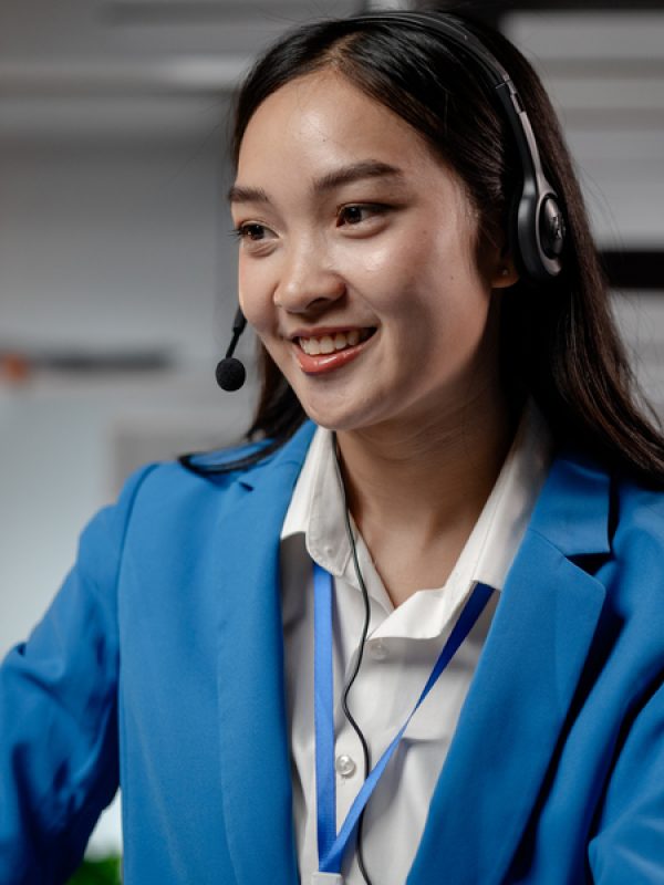 Asian woman wearing headphones and talking to customers. Call center employees answer the phone to help and answer questions from customers who call to use the service. Call center concept.